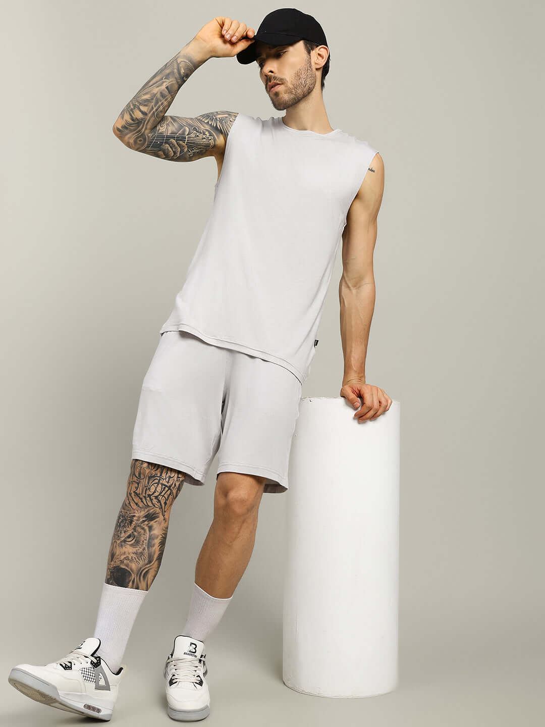 Man wearing STRENGTH FREAK LIGHT GREY shorts paired with a matching sleeveless top, showcasing casual athletic style.