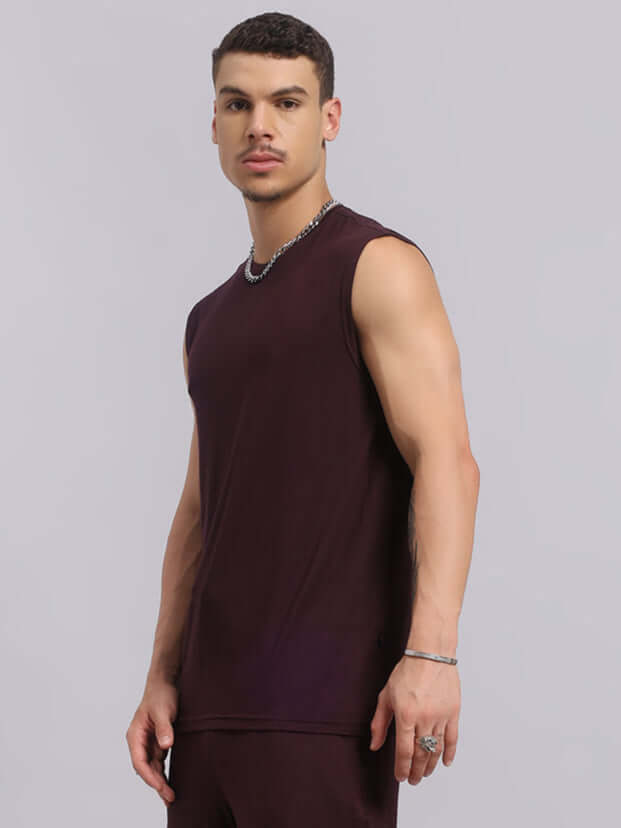 Model wearing Sleeveless Strength Freak Fitness T-Shirt in wine color, showcasing casual summer fashion suitable for beach or casual outings.