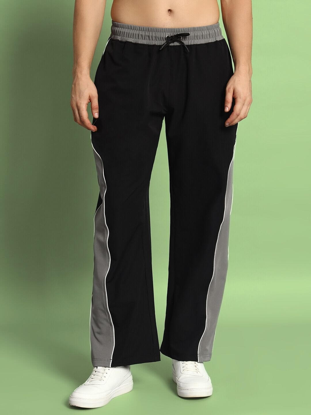 Model wearing black-grey STROM relaxed fit cargo pants with customizable size option, shown against a green background.