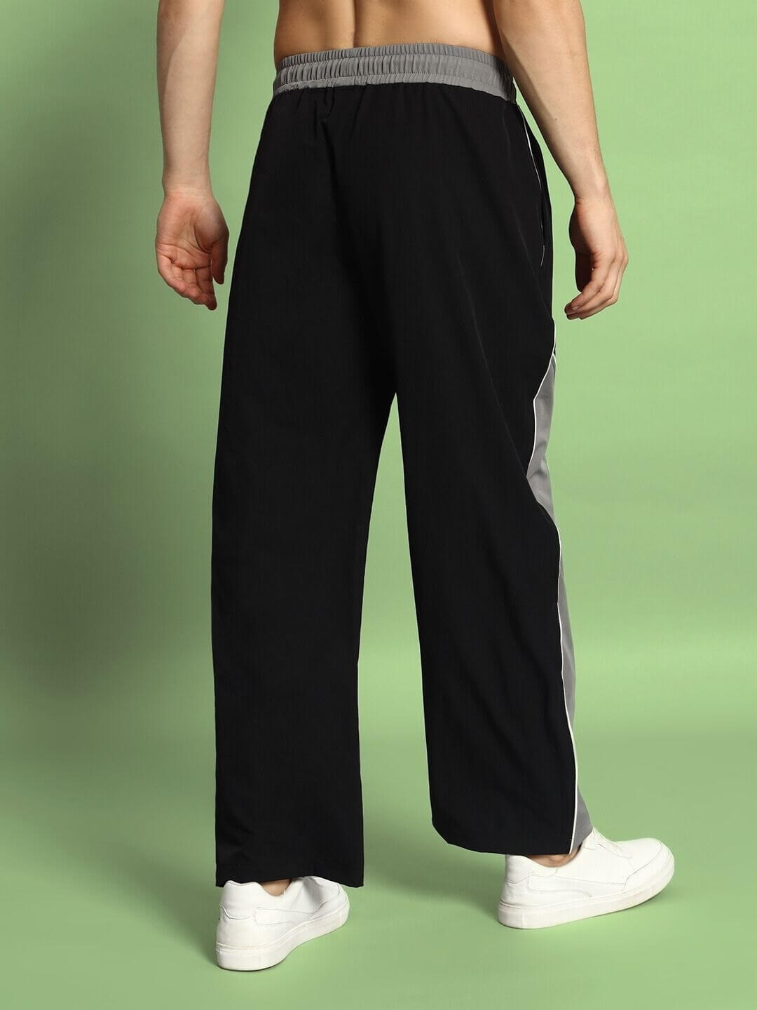 Back view of a person wearing Strom Relaxed Fit Cargo Pants in black-grey, showcasing wide leg design and elastic waistband.