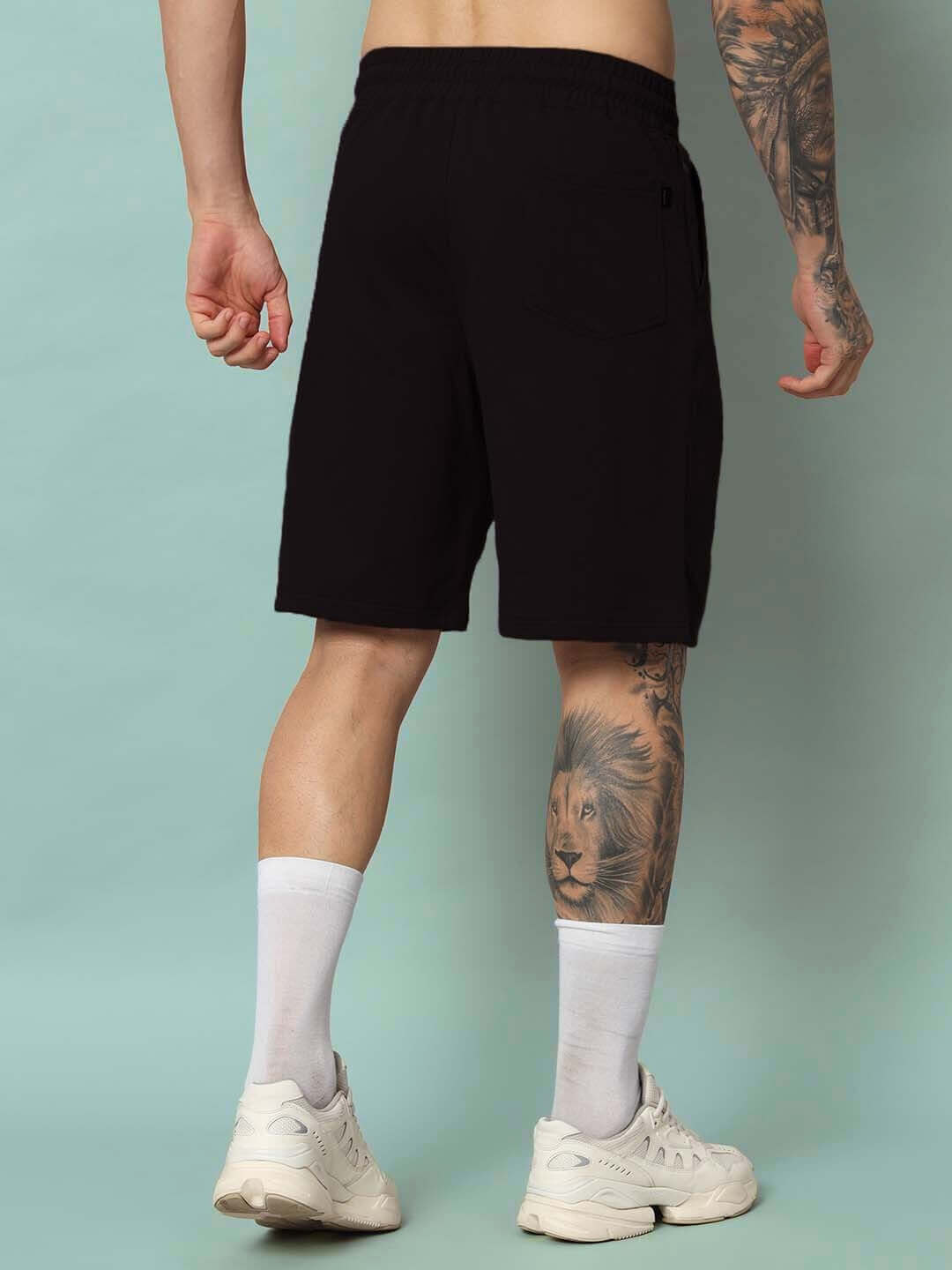 Back view of StrongFit Regular Fit Black Shorts worn by a tattooed person, highlighting comfort and style for custom fit orders.