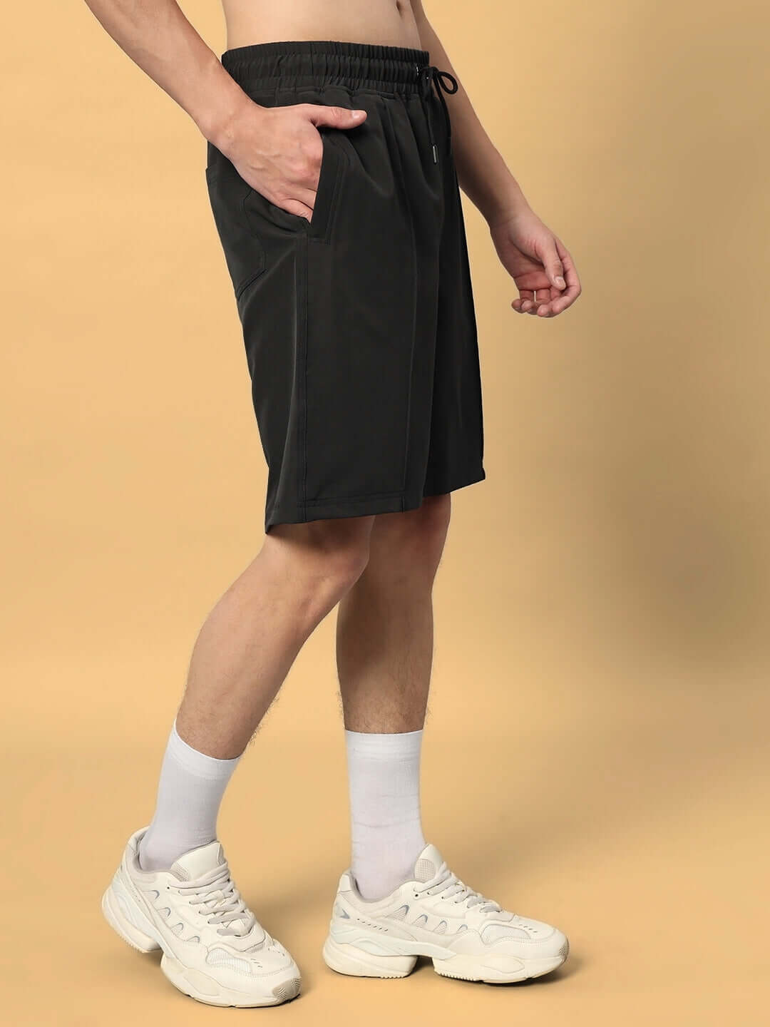 Side view of model wearing dark grey sturdy front plated shorts, showcasing comfortable fit and casual style, perfect for custom sizing.