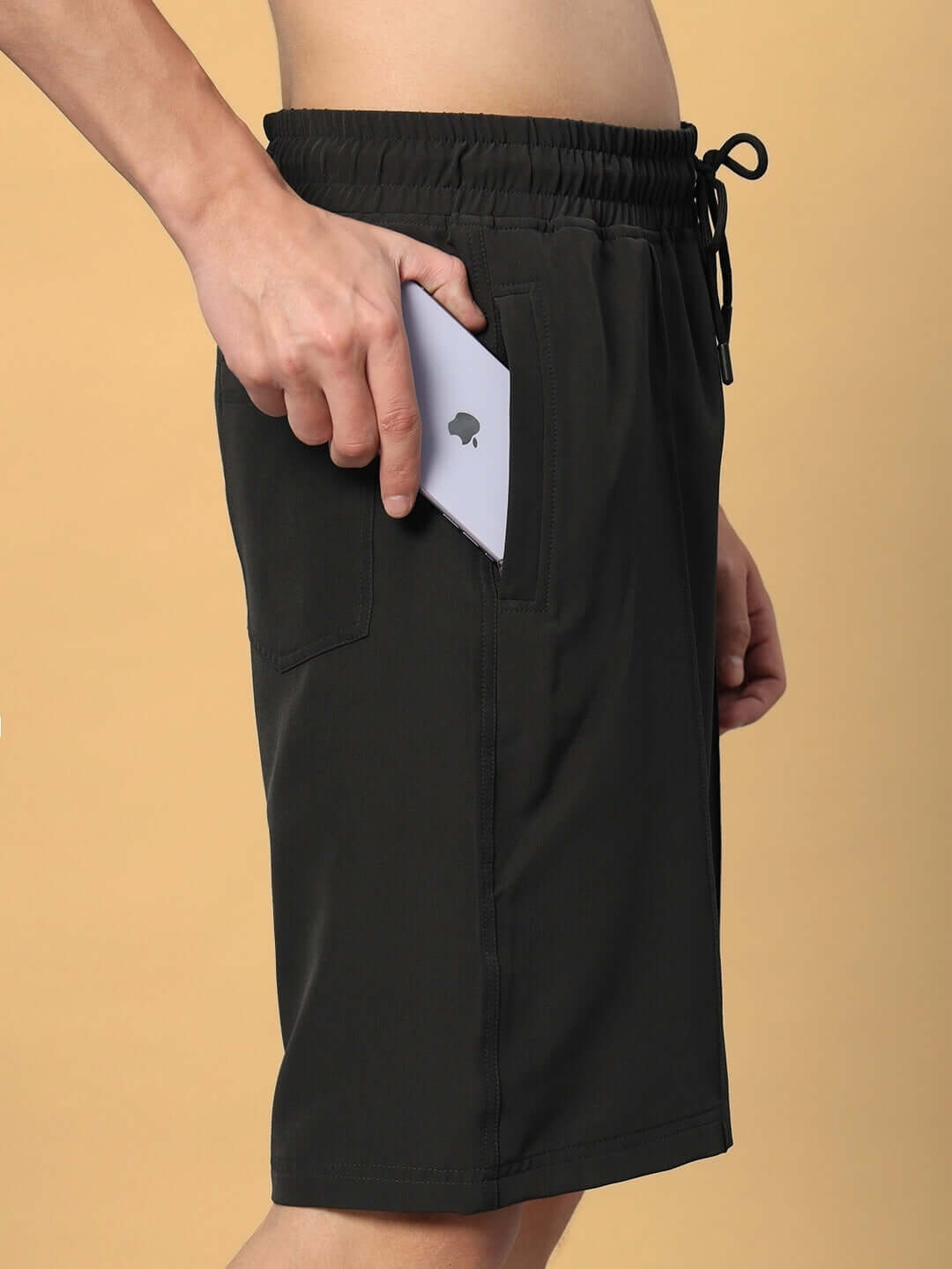 Person wearing dark grey sturdy front plated shorts with a smartphone in pocket