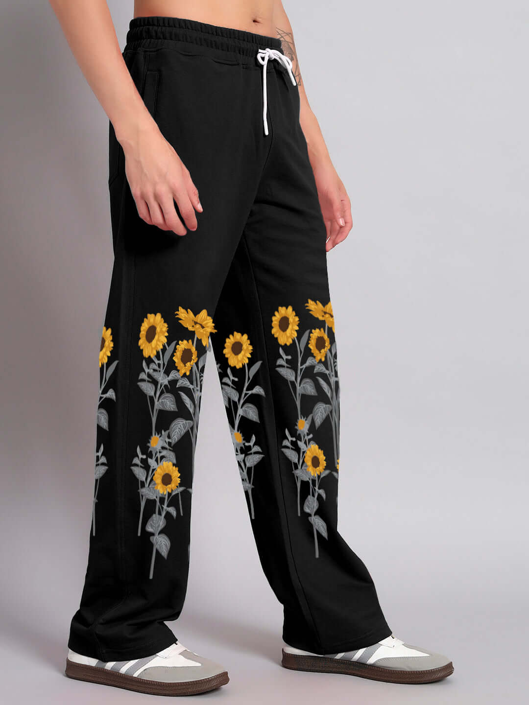 Black sunflower relaxed-fit jogger pants with floral pattern, modeled by a person for DUDS made-to-order collection.