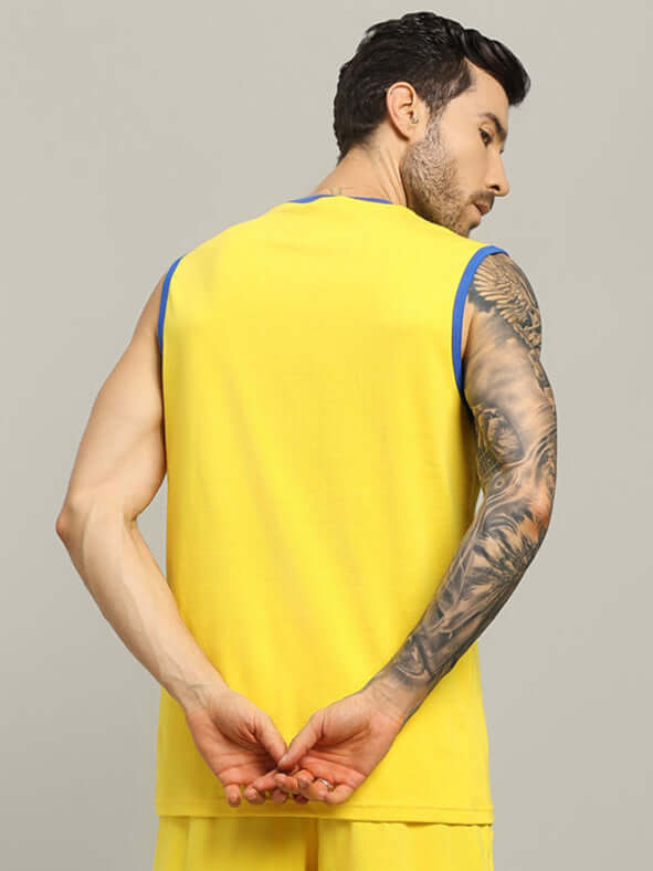 Man wearing yellow super hero oversized t-shirt, showcasing tattooed arm, ideal for trendy summer fashion