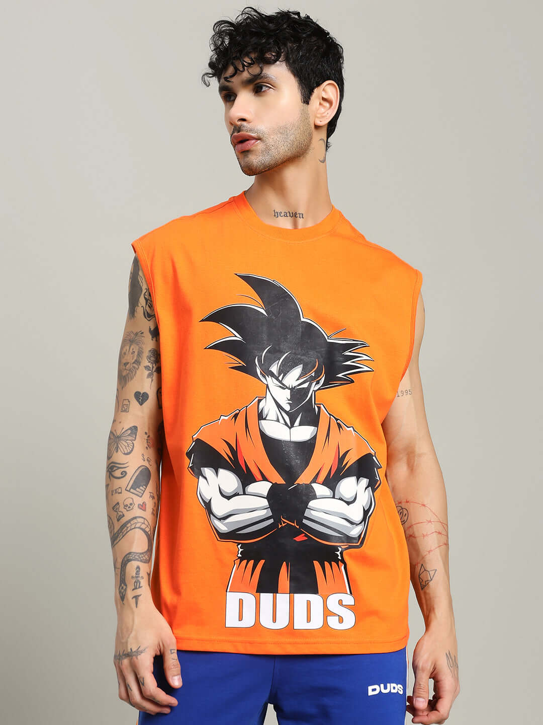 Man wearing an orange SUPER SAIYAN GYM T-shirt with a cartoon character graphic, offering custom fit options for personalized sizing.