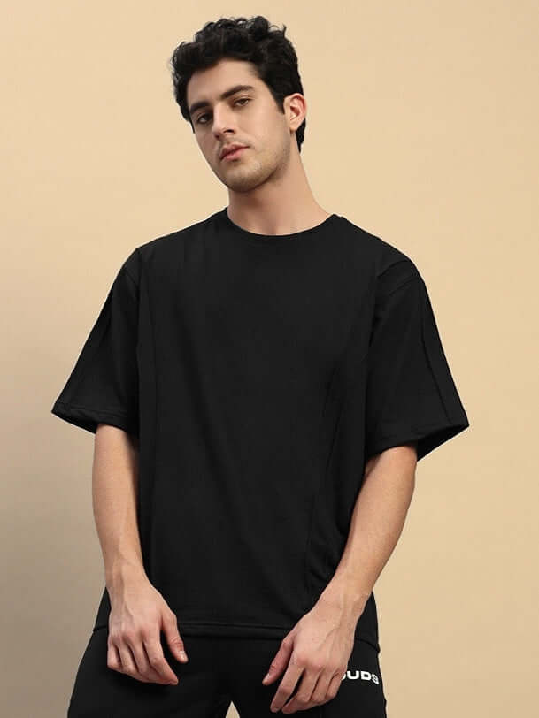 Man wearing a SUPERIOR OVER SIZED T-SHIRT in black, made from premium heavy gauge fabric, 97% cotton and 3% elastane, perfect for casual wear.