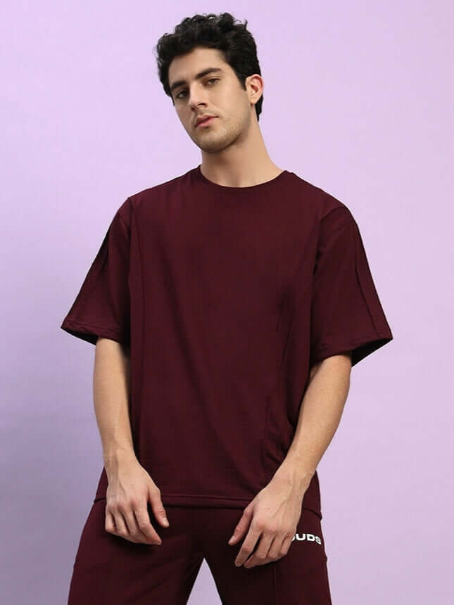 Model wearing maroon Superior Oversized T-shirt made of premium cotton French Terry with elastane, emphasizing comfort and style.