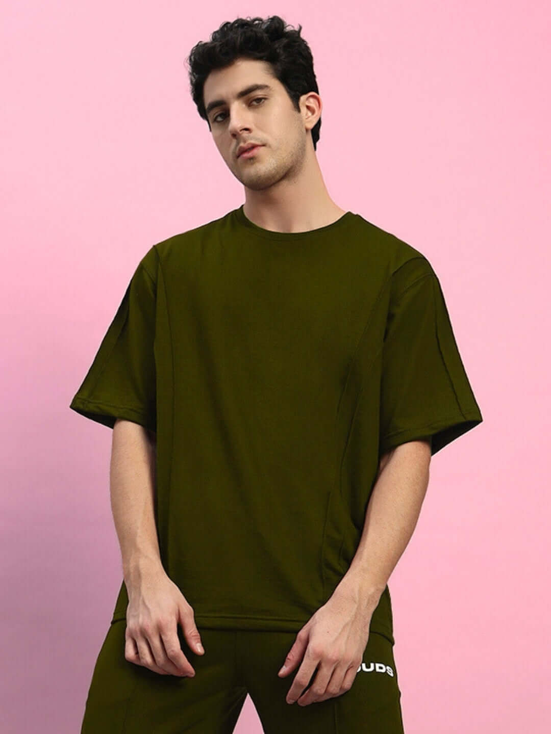Model wearing olive green oversized t-shirt made from premium cotton blend, showcasing relaxed fit and casual style.