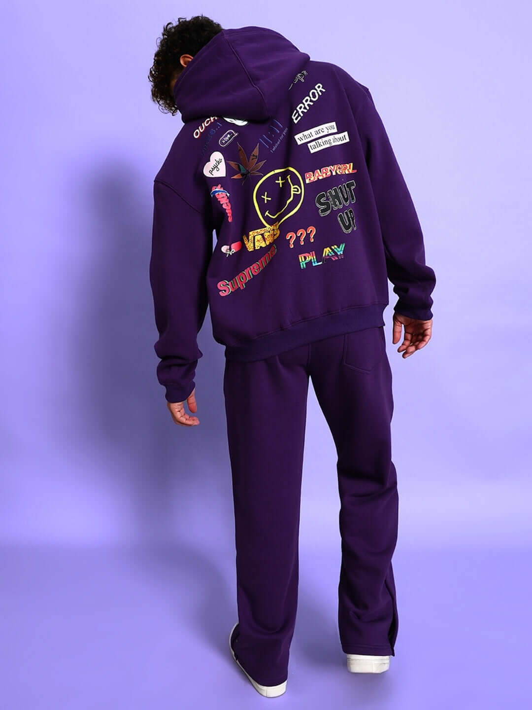 Model wearing SUPREME COTTON FLEECE CO-ORD PURPLE hoodie and joggers set, showcasing trendy streetwear style on a purple background.