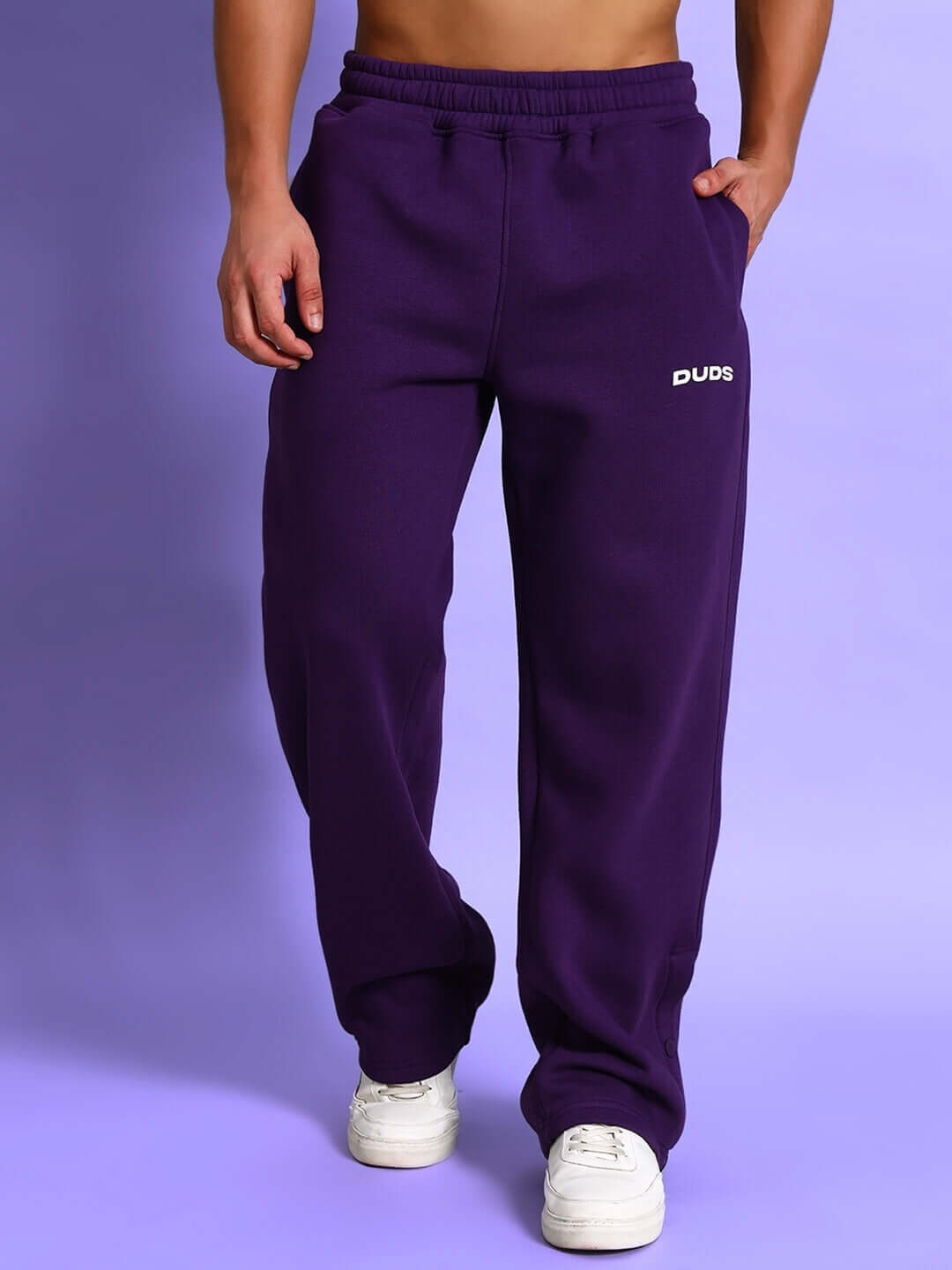 Model wearing SUPREME COTTON FLEECE CO-ORD PURPLE joggers, showcasing streetwear style with a vibrant purple color and relaxed fit.