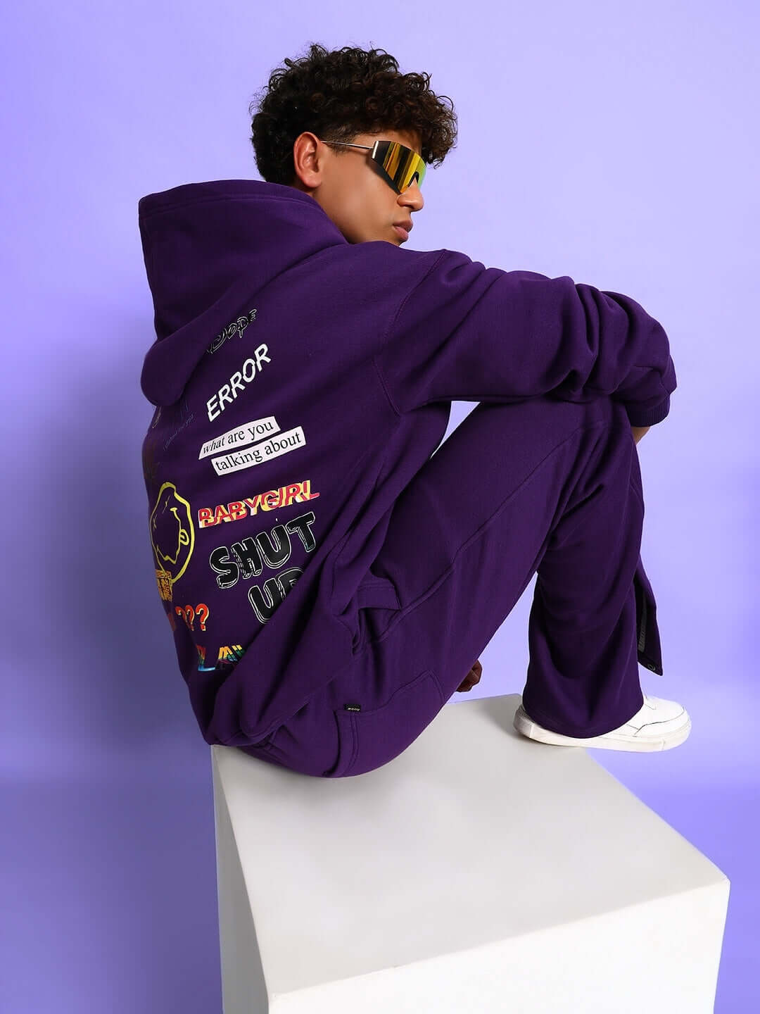 Person wearing SUPREME COTTON FLEECE CO-ORD PURPLE, showing side view with graphic details against purple background.