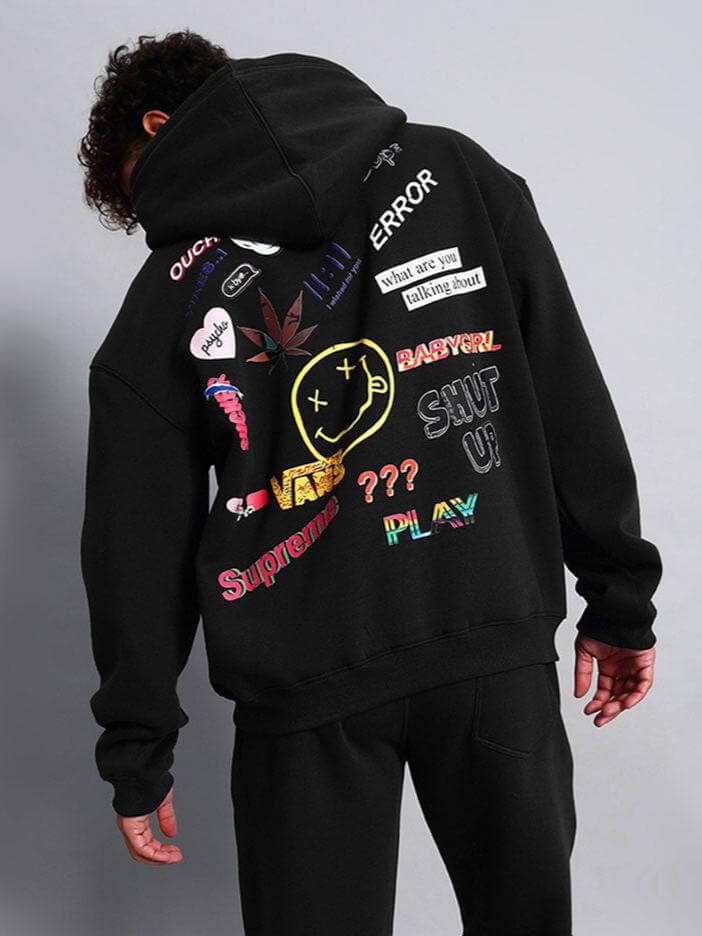 Person wearing WEARDUDS SUPREME FLEECE HOODIE BLACK with colorful graphic designs on the back.
