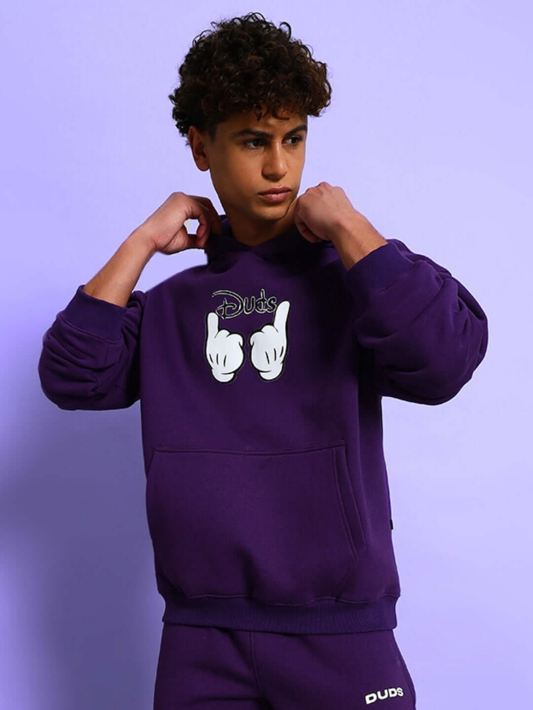 Person wearing SUPREME COTTON FLEECE HOODIE PURPLE, stylish streetwear in rich purple color, showcasing comfort and modern design.