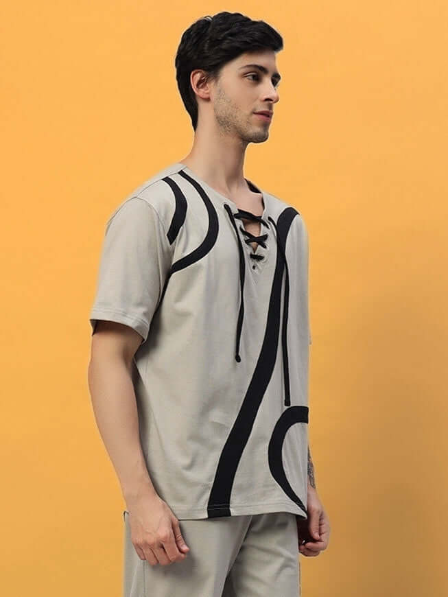 Man wearing a grey surfing designer oversized T-shirt with abstract black patterns, crafted from premium cotton and elastane blend.