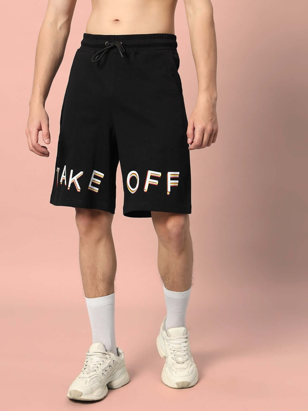 Black TAKE OFF regular fit shorts with lettering, available with custom fit option, showcased on a model against a pink backdrop.