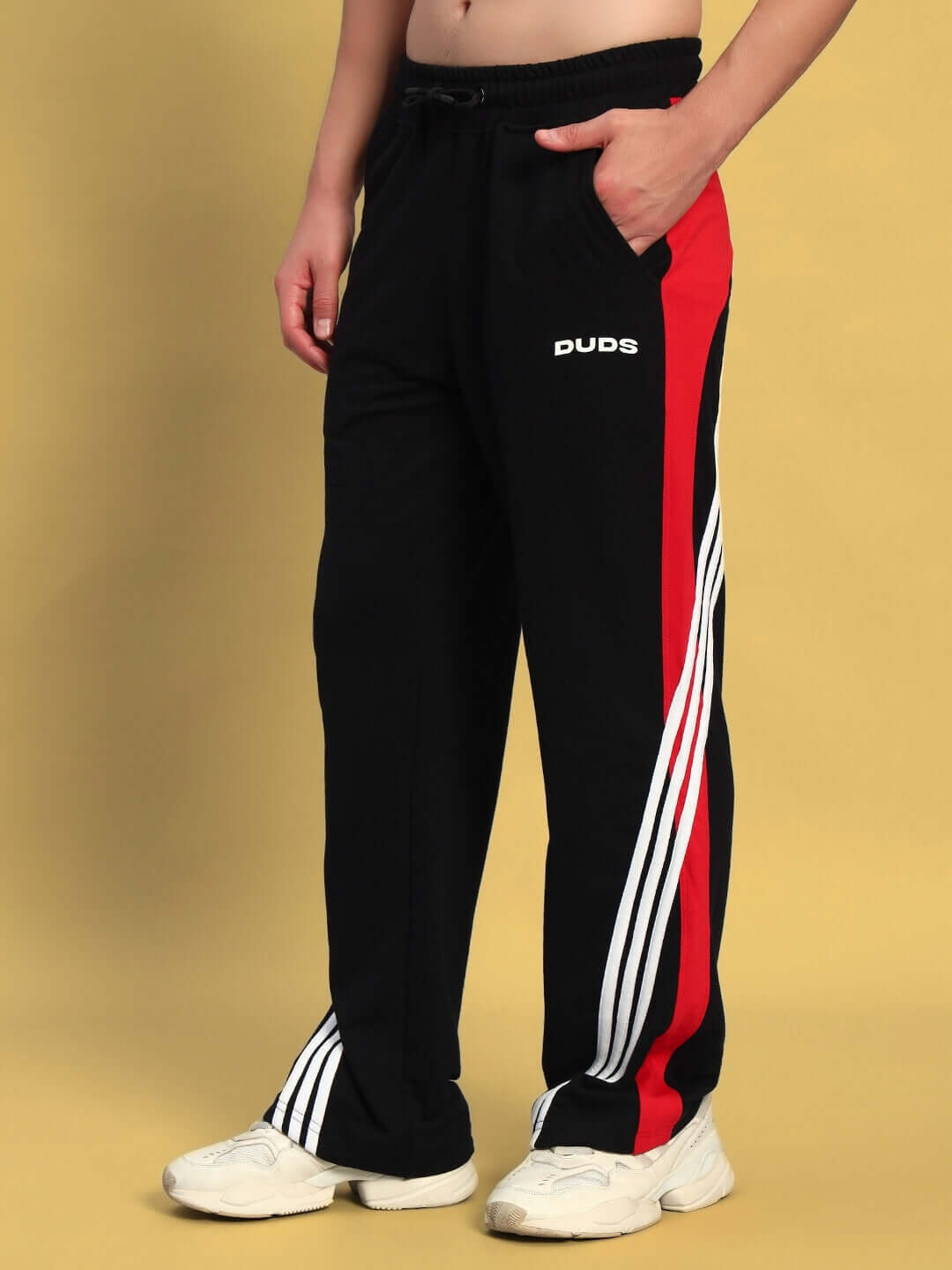 TANGLE relaxed-fit joggers in black and red with side stripes, worn by a standing person, made by DUDS.