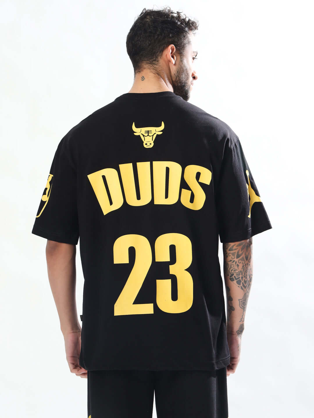 Black Taurus oversized t-shirt with bold yellow 'DUDS' text and number '23', worn by a model, showcasing custom fit options.