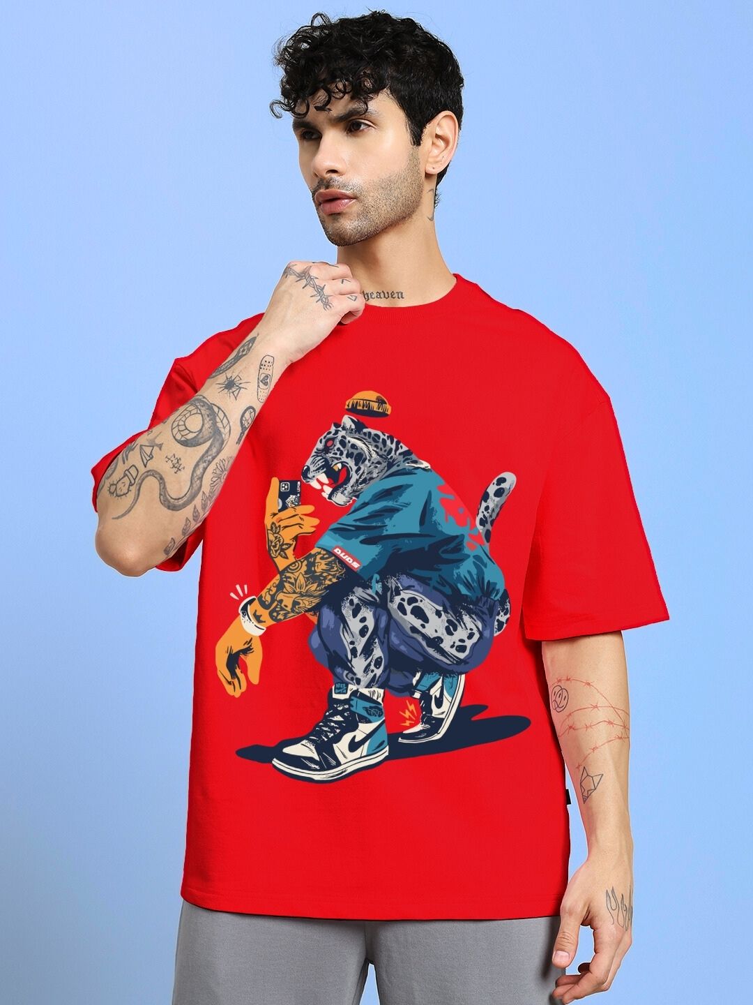 Model wearing TEKKEN KING T3 OVER-SIZED T-SHIRT RED with graphic design, showcasing bold style and comfort.
