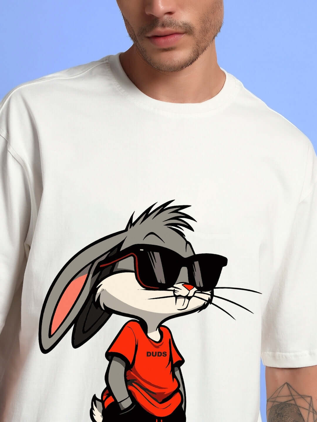 Man wearing THINK BIG BUNNY TOONS Co-ord set T-shirt in off white with cartoon bunny in sunglasses, casual fashion.