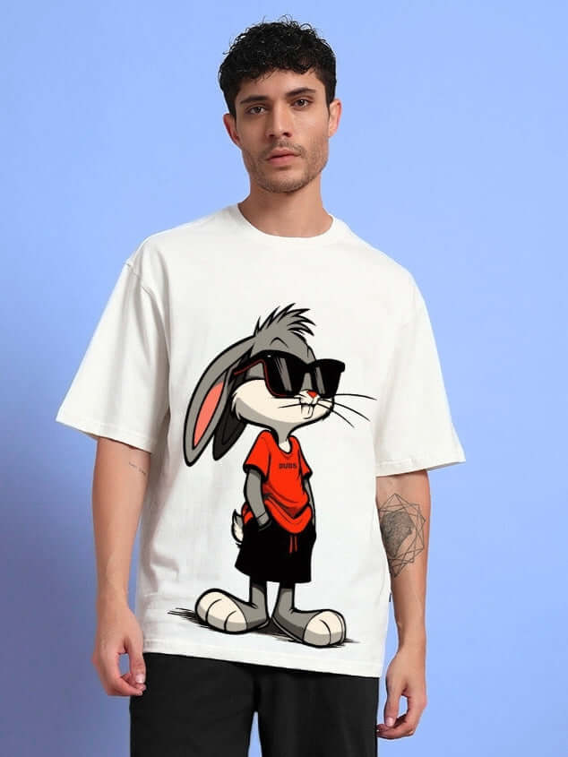 Model wearing THINK BIG BUNNY TOONS oversized t-shirt in off white, featuring a cartoon bunny graphic. Ideal for trendy summer looks.