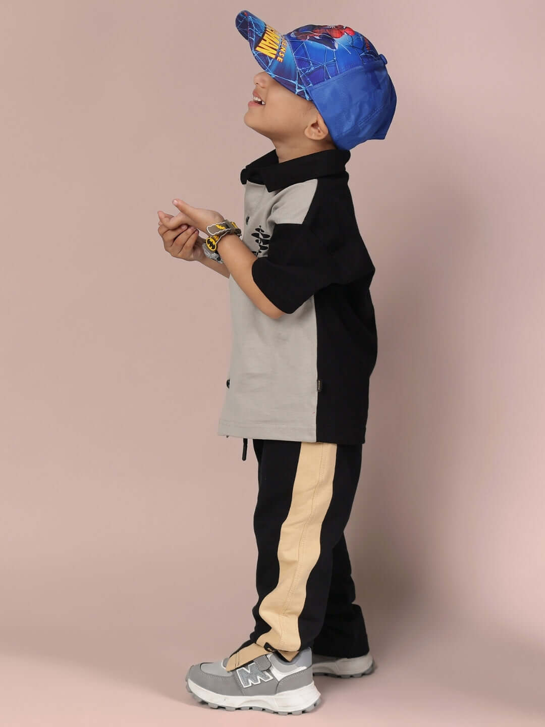 Child wearing TINGE CO-ORD FOR BOYS & GIRLS GREY BLACK with a blue cap and sneakers, side view.
