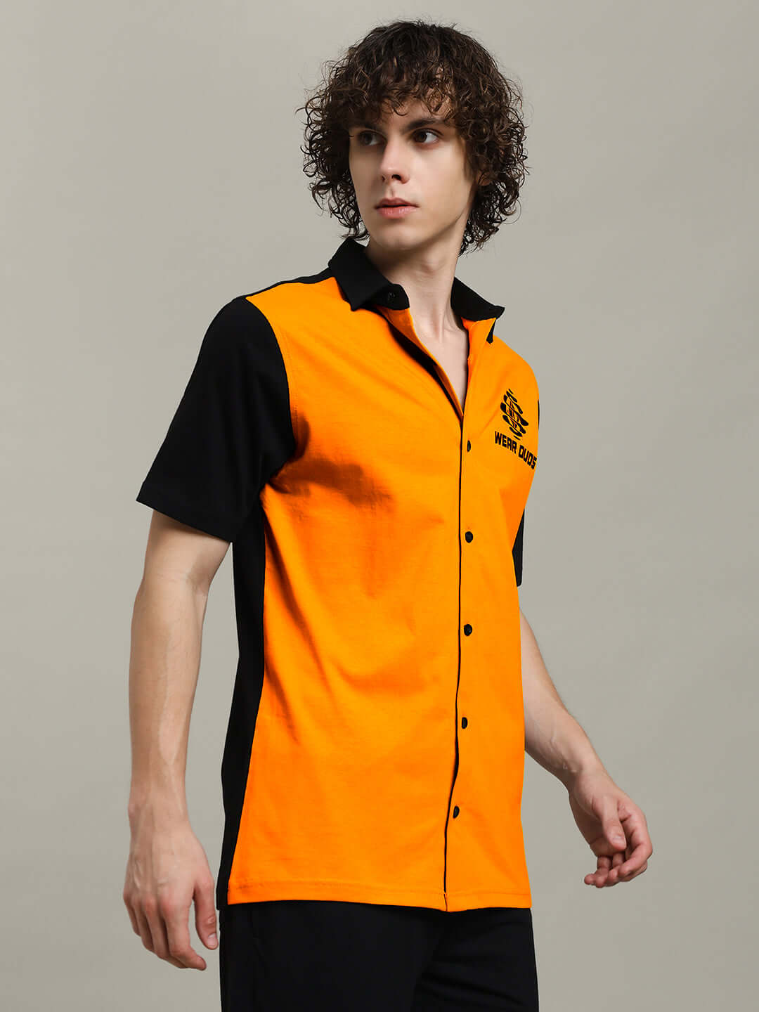 Model wearing TINGE regular fit shirt in orange and black, showcasing short sleeves and button-up style, ideal for casual occasions.