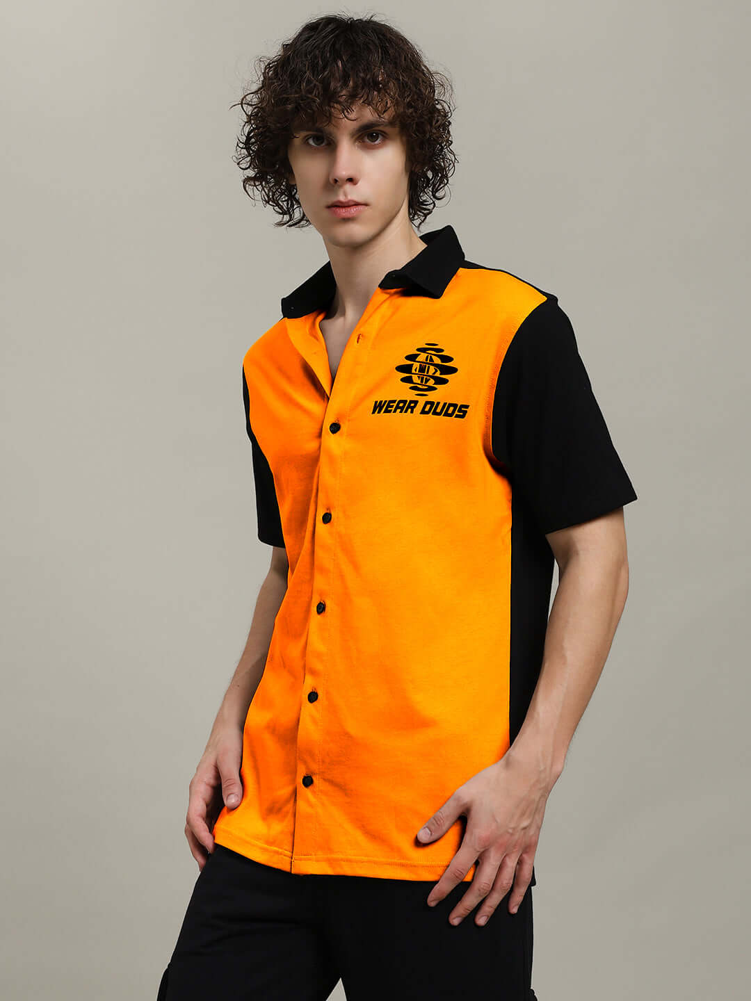 Model wearing TINGE regular fit orange-black shirt by DUDS, featuring button-up front and dual-tone design.