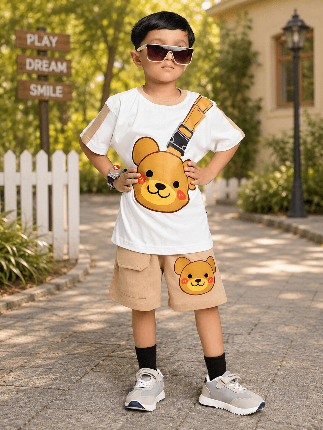 TINY TREND BEAR COOL SHORTS FOR BOYS GIRLS BEIGE worn by a young child with a bear-themed outfit outdoors.