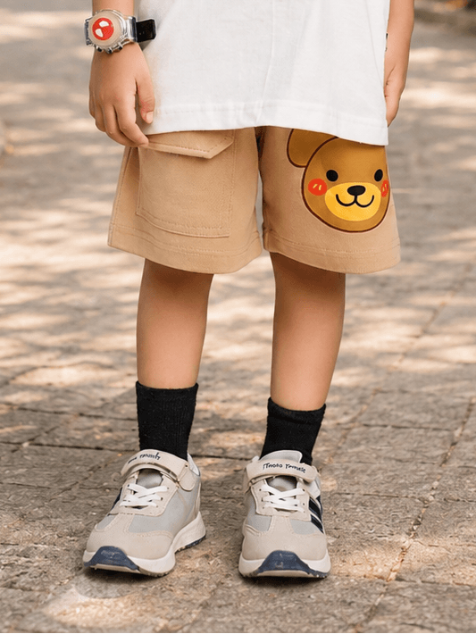 TINY TREND BEAR COOL SHORTS FOR BOYS GIRLS BEIGE worn by a child, featuring a cute bear design and paired with sneakers.