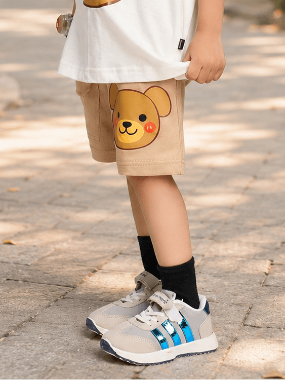 TINY TREND BEAR COOL SHORTS FOR BOYS GIRLS BEIGE worn by a child with stylish sneakers, displaying a cute bear design.
