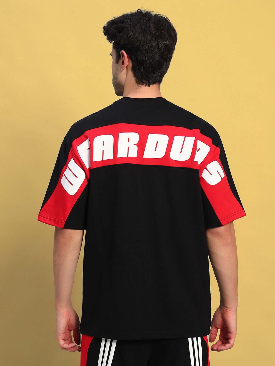 Back view of TITAN oversized black-red T-shirt, featuring bold lettering and crafted from premium cotton blend. Ideal for casual style.