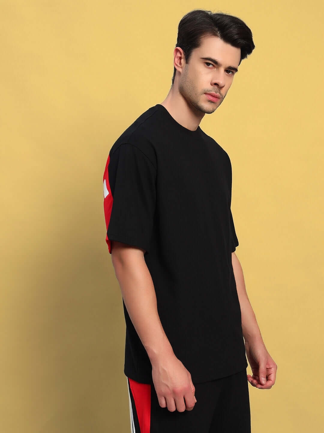Model wearing TITAN oversized black-red t-shirt, premium cotton fabric, stylish and comfortable for casual wear.