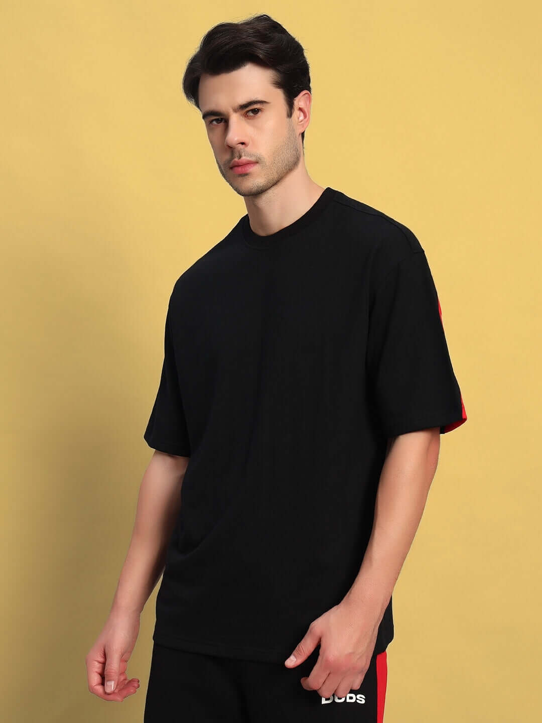 Man wearing black-red Titan oversized T-shirt made of premium cotton with French terry, highlighting comfort and style. Made in India.