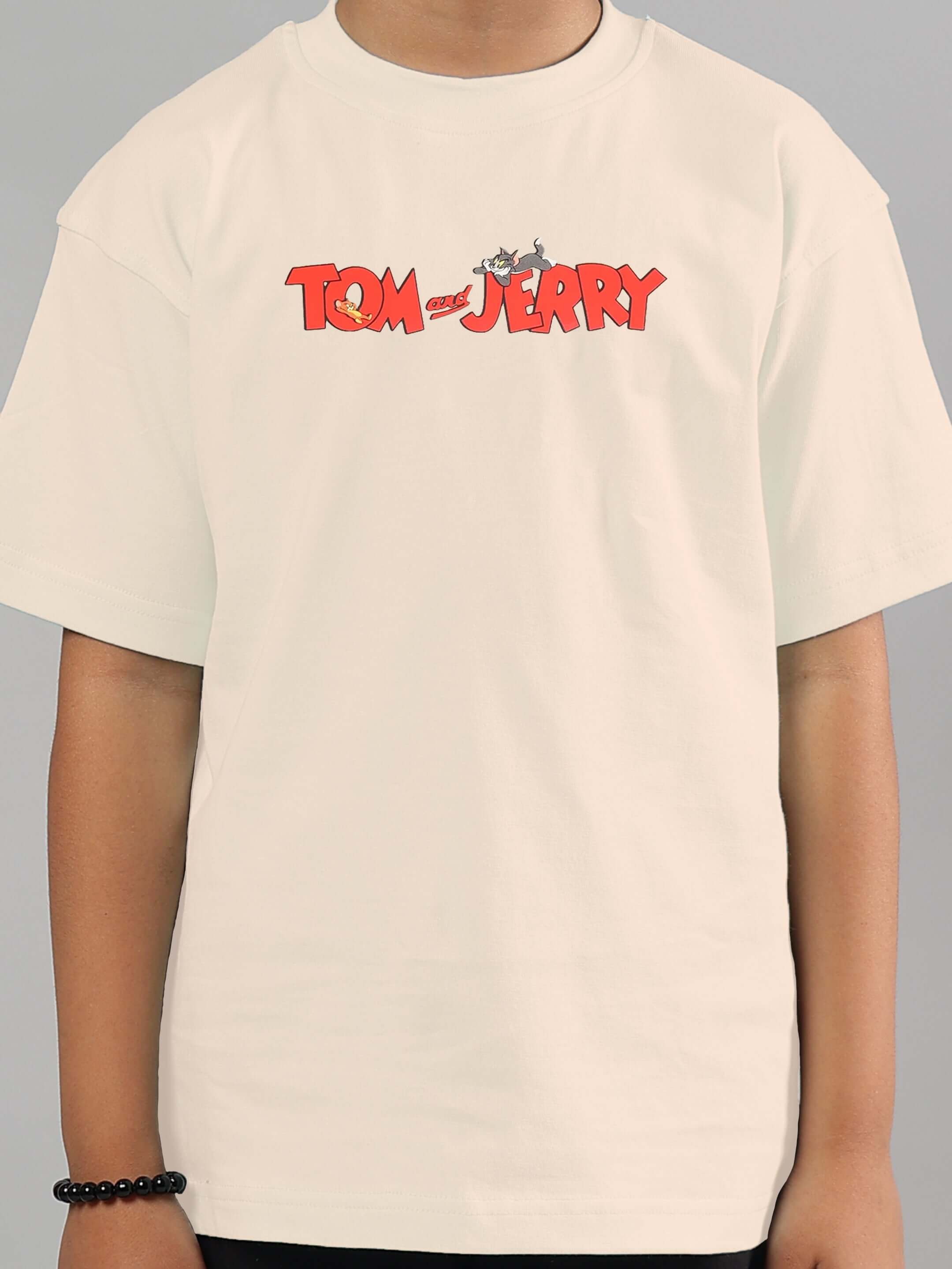 Child wearing off-white Tom & Jerry T-shirt by DUDS, suitable for boys and girls, showcasing iconic cartoon logo. Custom fit available.