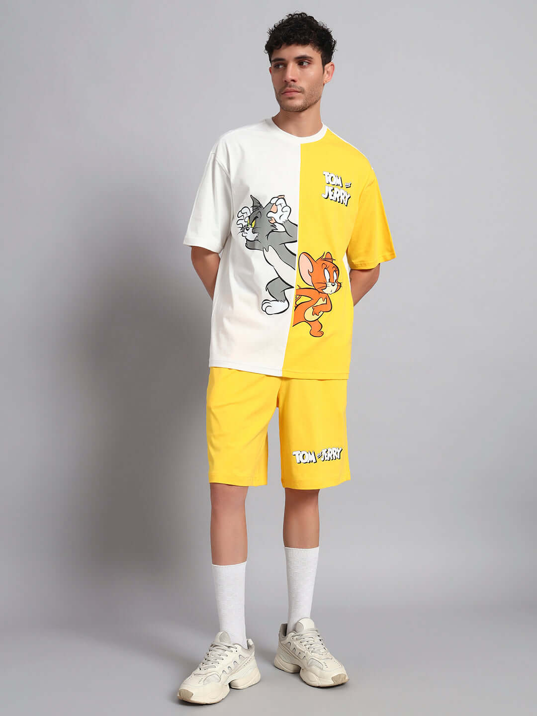 Man wearing a Tom & Jerry yellow off-white co-ord set made from premium cotton French terry lycra, posing stylishly.