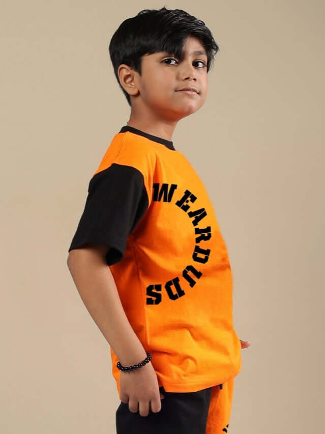 TRACK & FIELD T-SHIRT FOR BOYS & GIRLS BLACK-ORANGE Boy wearing a black and orange TRACK & FIELD T-shirt by DUDS, side view with text design, ideal for customizing size options.