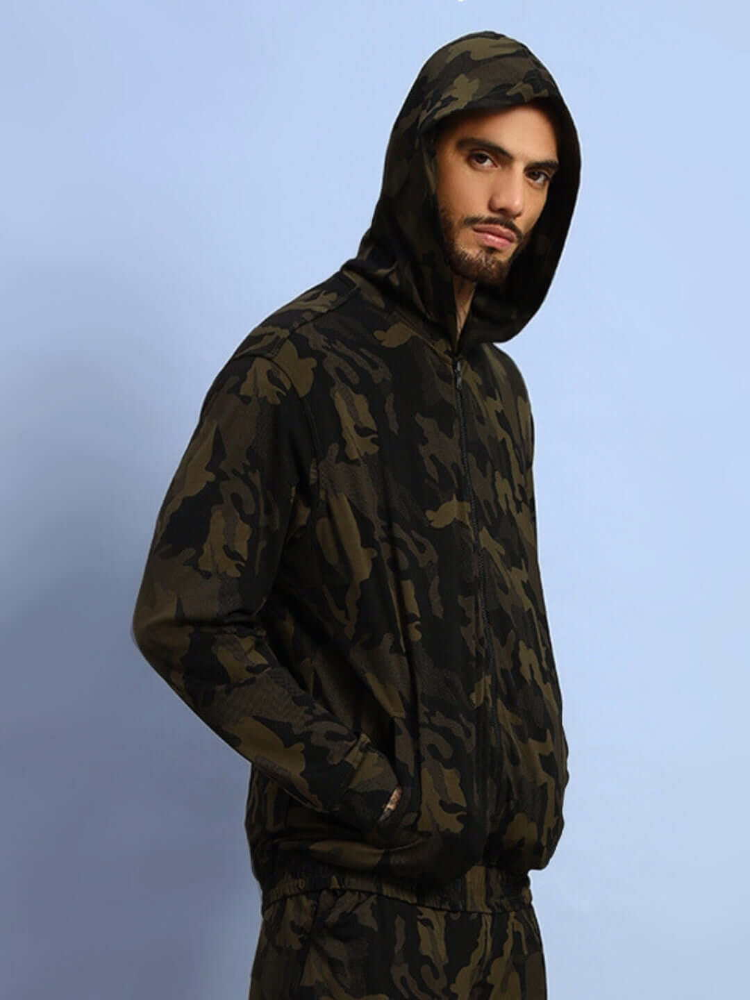 Model wearing DUDS Trench Camouflage Jacket in Camo Green with hood, showcasing military-inspired fashion style.