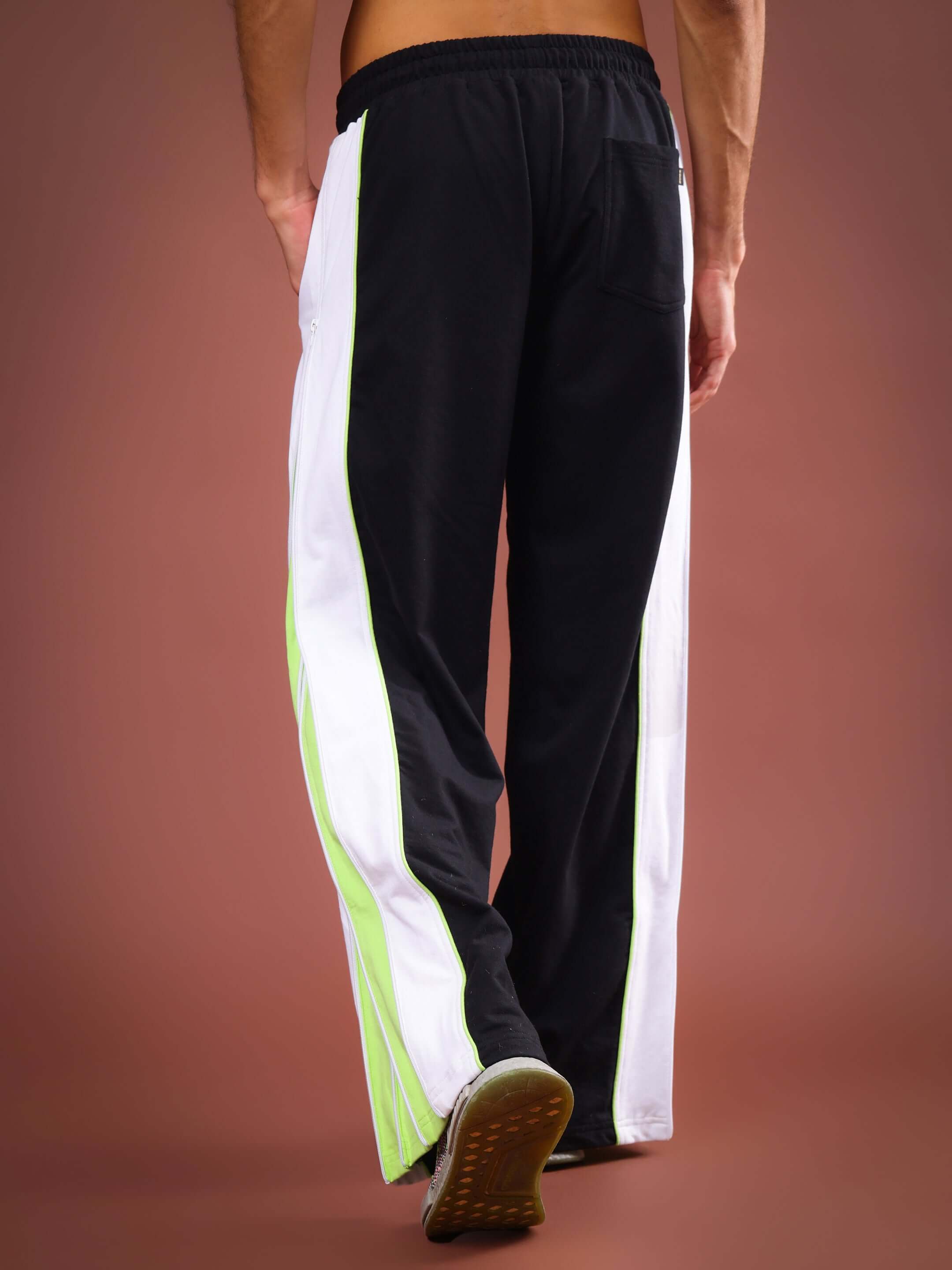 Back view of TRIUMPH Multi Zipper Joggers in Black Neon with side stripes, highlighting the unique design and tailored fit options.