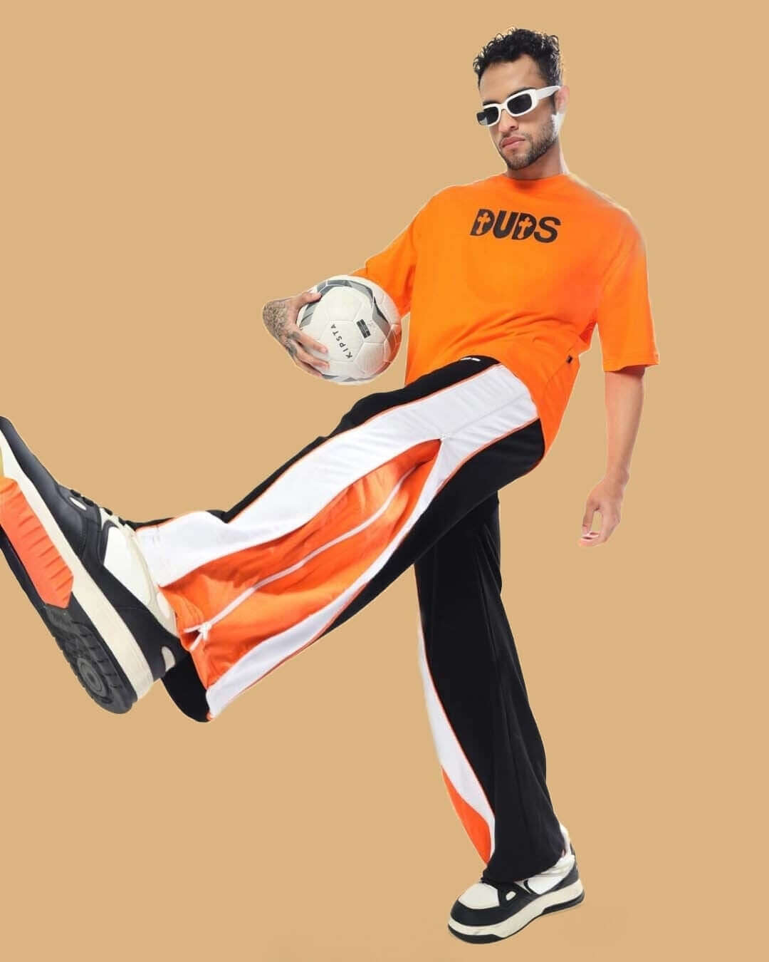 Model wearing TRIUMPH Multi Zipper Joggers in Black Orange with a sporty style.