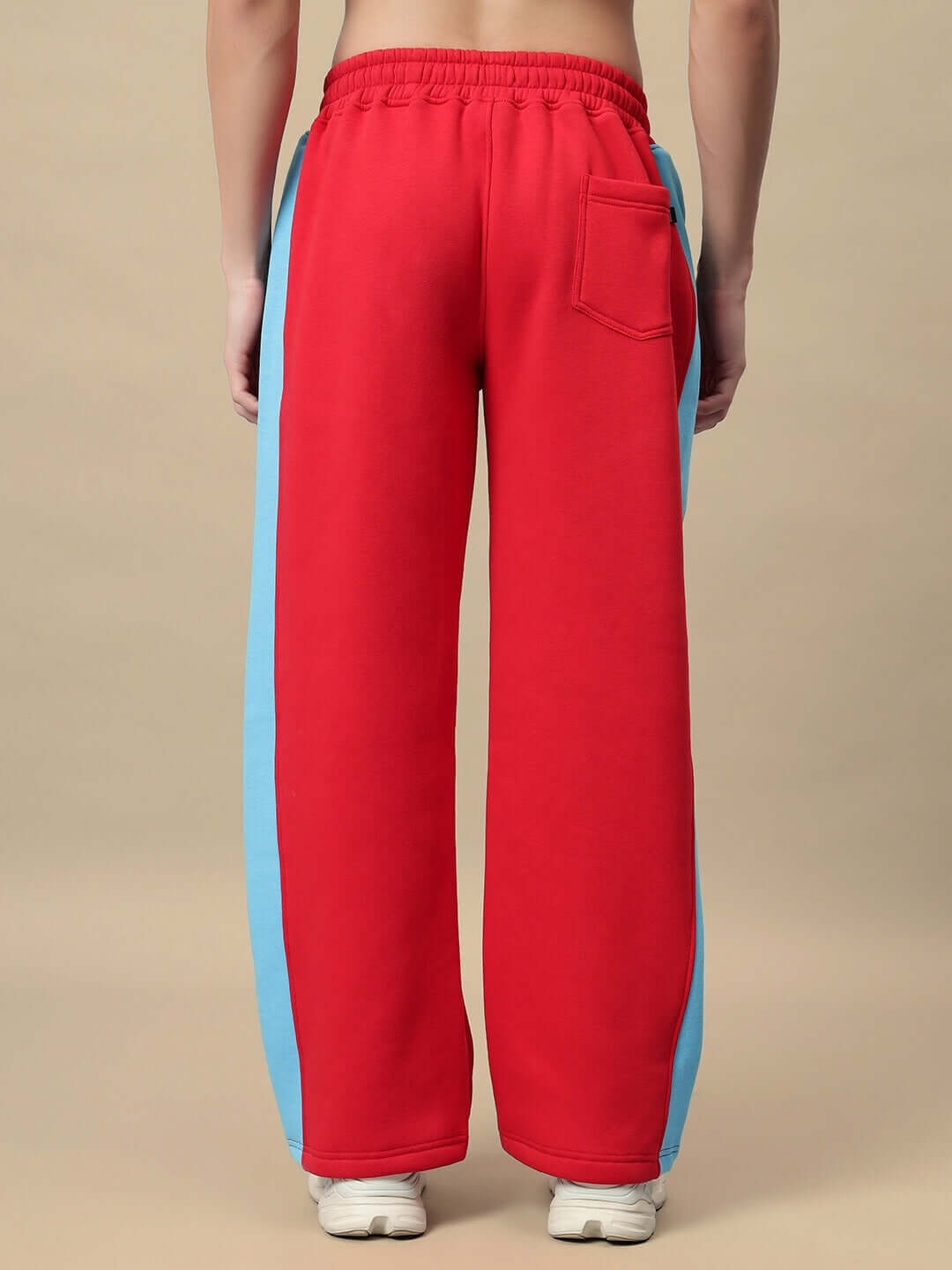 Back view of Trunkit Fleece Colorblock Cargo Pants in red and blue, featuring elastic waistband and rear pocket, showcasing streetwear style.