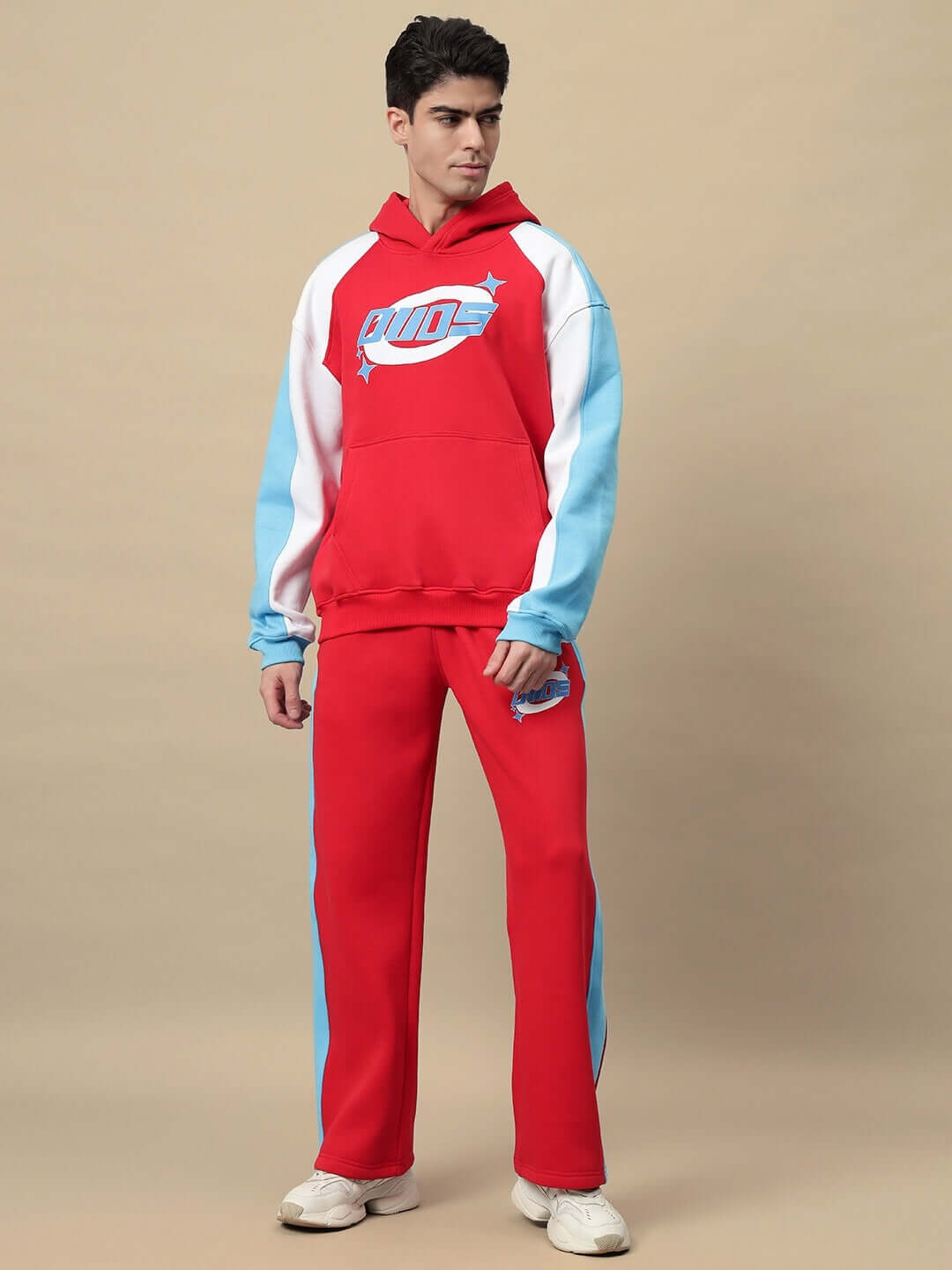 Model wearing Trunkit Fleece Colorblock Cargo Pant and hoodie, showcasing bold streetwear style with red and blue colorblock design.