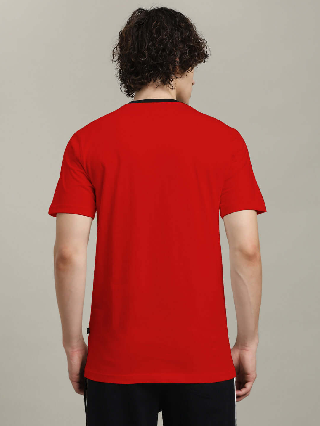 Back view of Trust No One Regular Fit Printed T-Shirt Red worn by a model, showcasing vibrant red color and casual style.