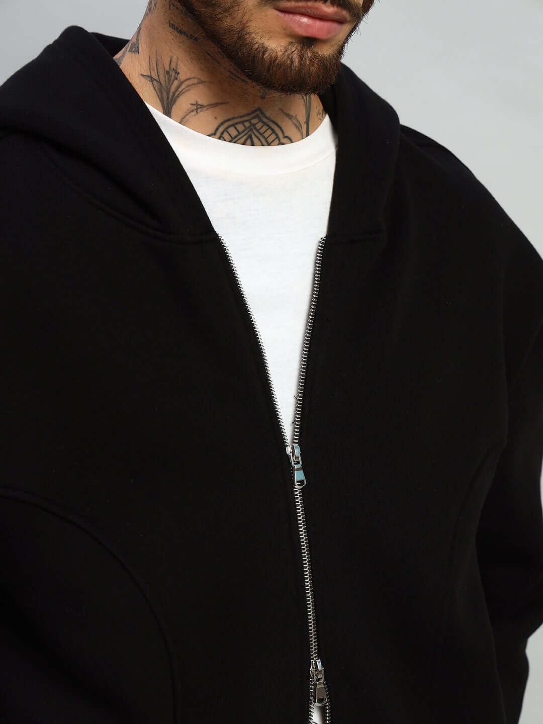 Man wearing WEARDUDS TWO FOLD ZIPPER HOODIE BLACK with tattoo visible on neck.