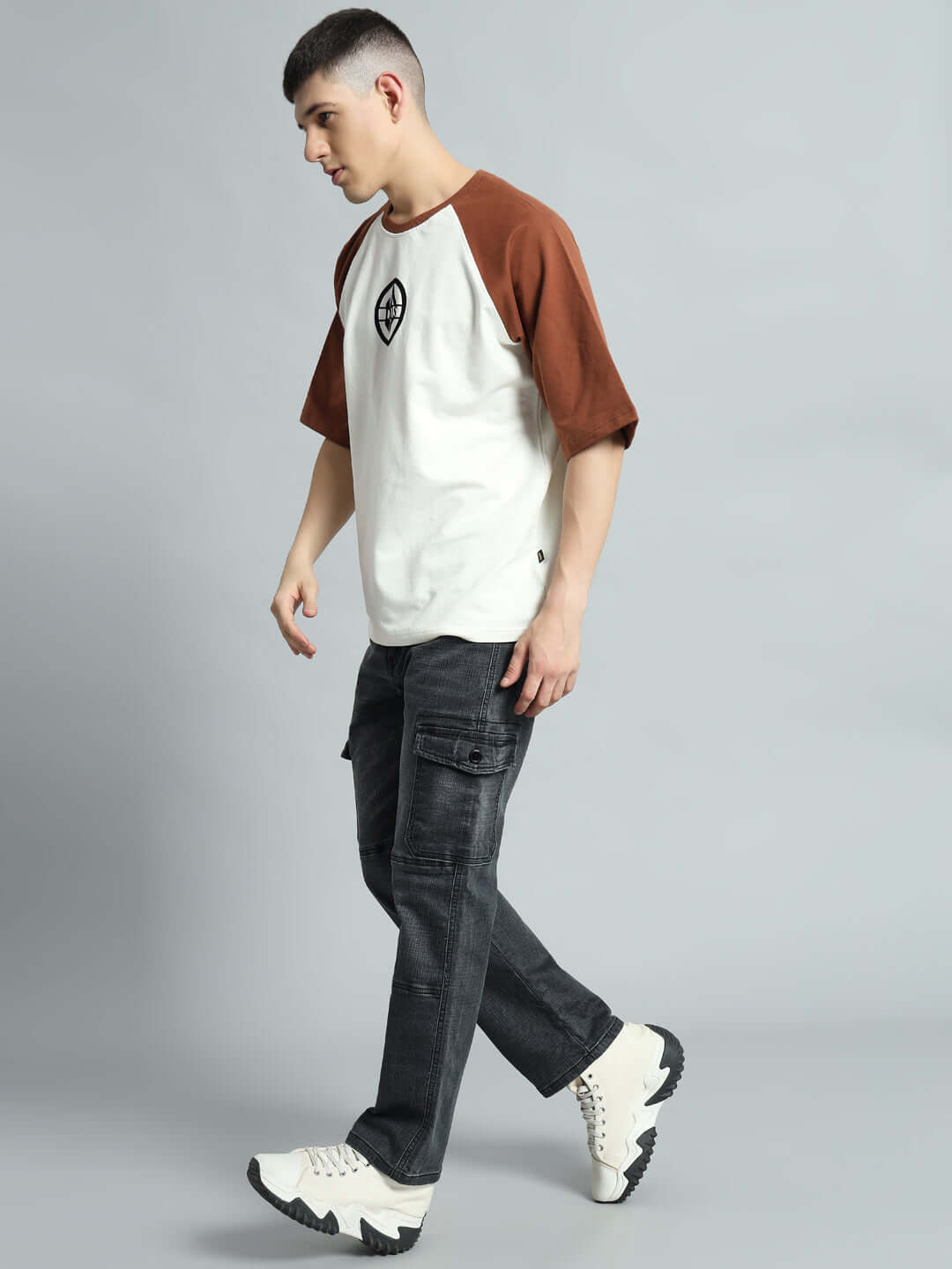 Model wearing TYRO relaxed grey denim cargo pants, styled with a casual t-shirt and sneakers, ideal for a modern laid-back look.