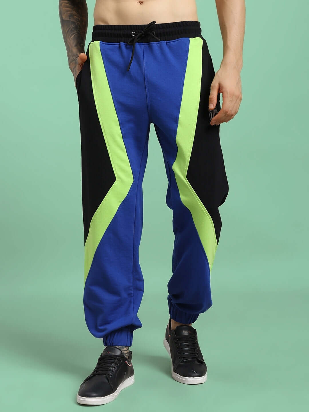 Man wearing ULTRA COLORBLOCK RELAXED-FIT JOGGERS BLUE-BLACK showcasing bold style and comfort in vibrant blue and black color blocking.