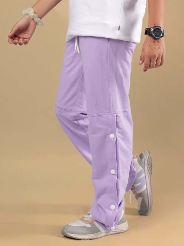 Child wearing lavender RACER JOGGER FOR BOYS & GIRLS with button details and sneakers.