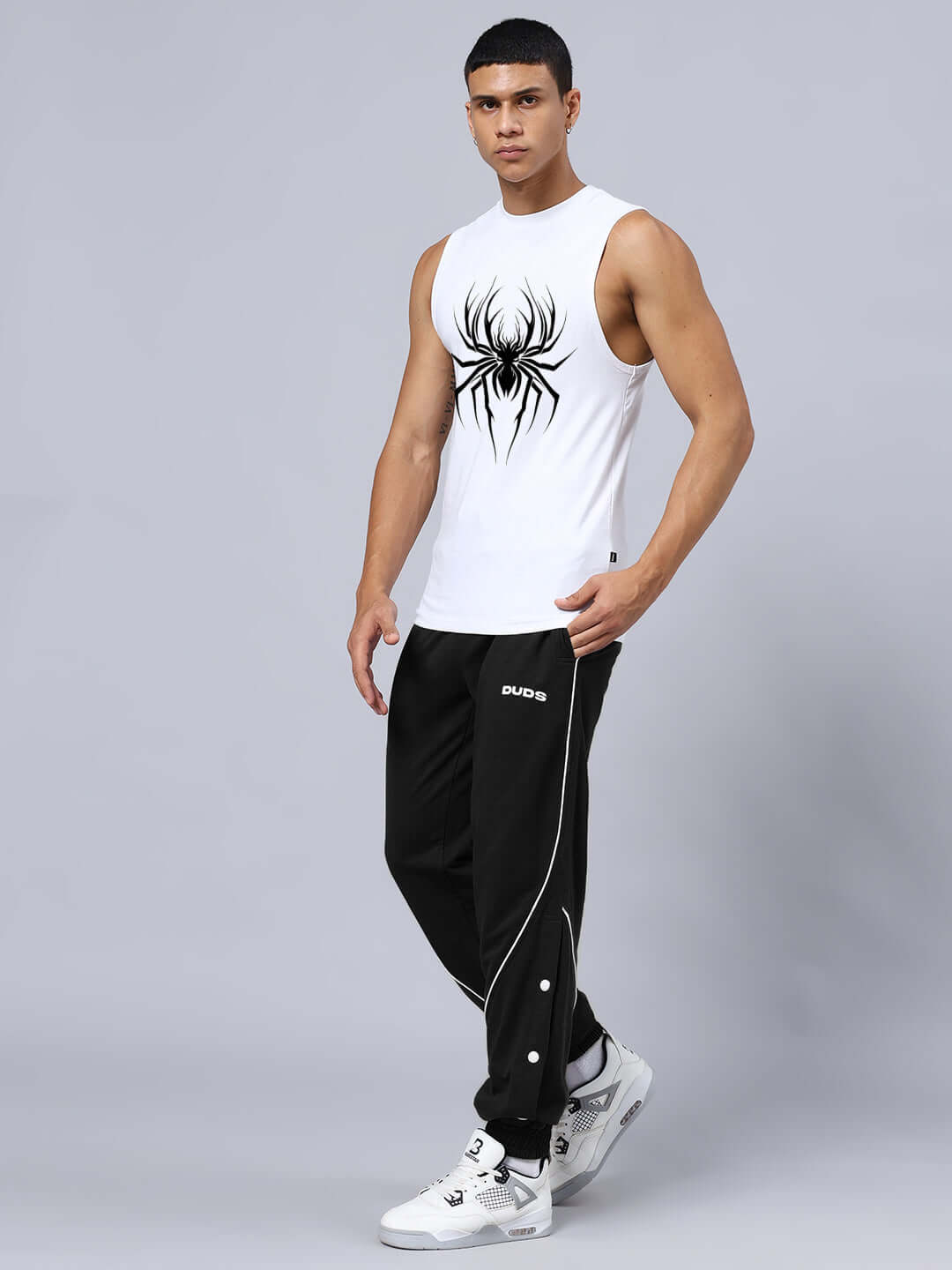 Man wearing SPIDER PRINTED GYM RELAXED FIT CO-ORD SET WHITE-BLACK with spider design, unisex relaxed fit, cotton material, joggers with drawstring.