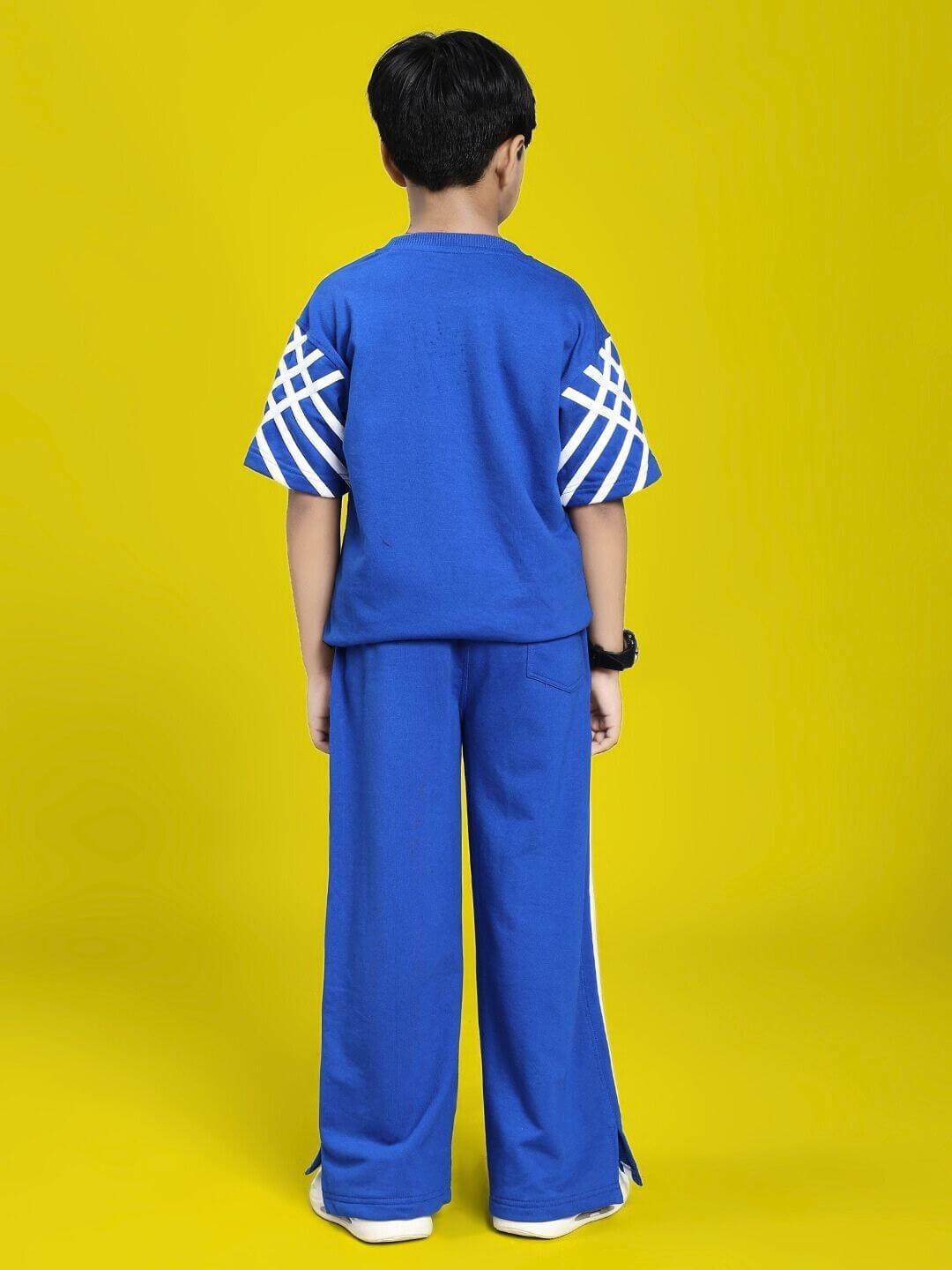 Child wearing UNITED STRIPE CO-ORD SET FOR BOYS GIRLS BLUE with striped sleeves, standing against yellow background.