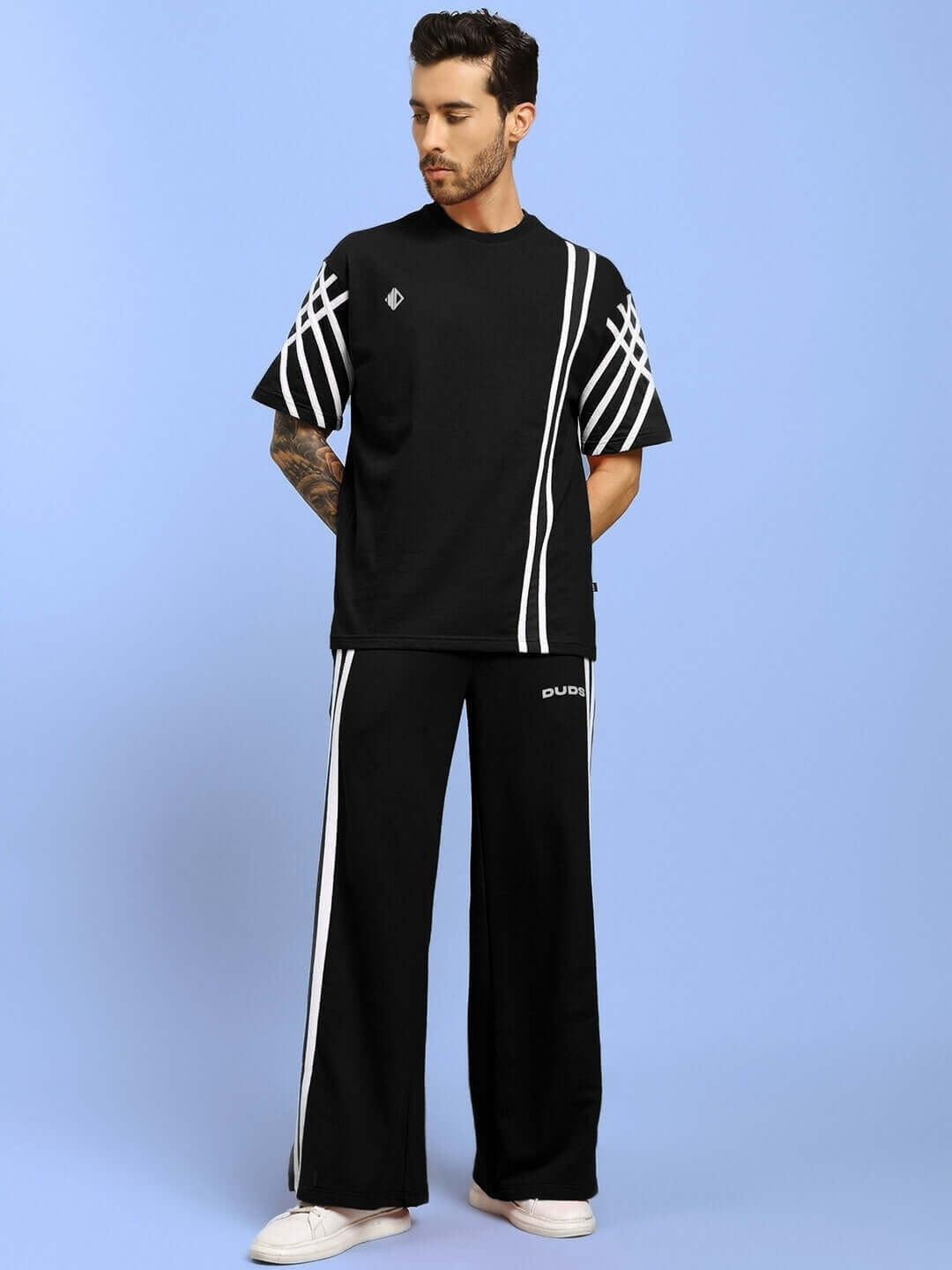 Model wearing UNITED STRIPE CO-ORD SET in black with white stripes, crafted from premium cotton French Terry Lycra and elastane.